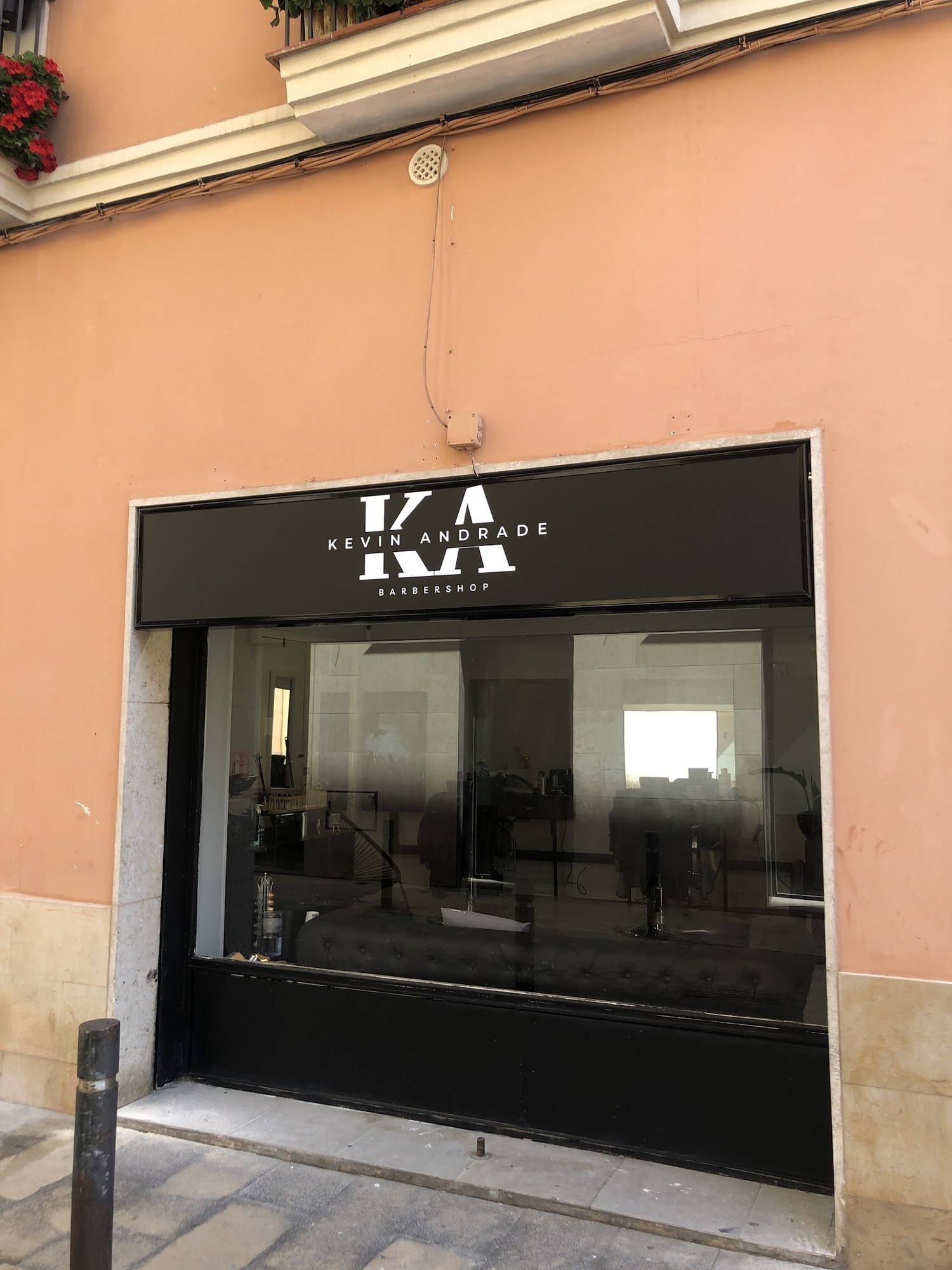 Fachada del local con el rótulo negro de la barbería.