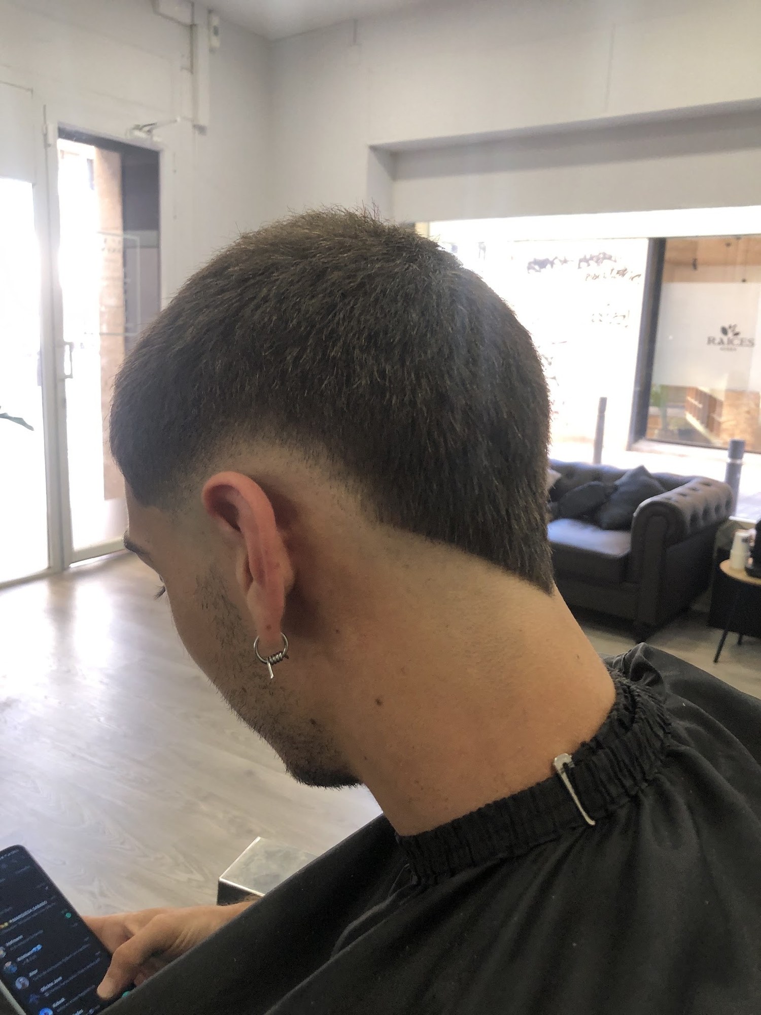 Corte degradado visto de lado, trabajado en el sillón de la barbería.